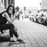 Junge Frau sitzt auf Treppenstufe